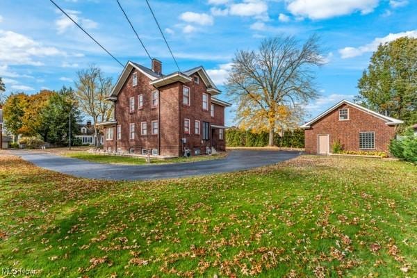 159 Kenilworth Ave SE, Warren, OH 44483 - view of side of property with a yard, driveway, brick siding, and a chimney
