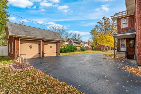 159 Kenilworth Ave SE, Warren, OH 44483 - view of side of property with an outdoor structure, brick siding, and a detached garage