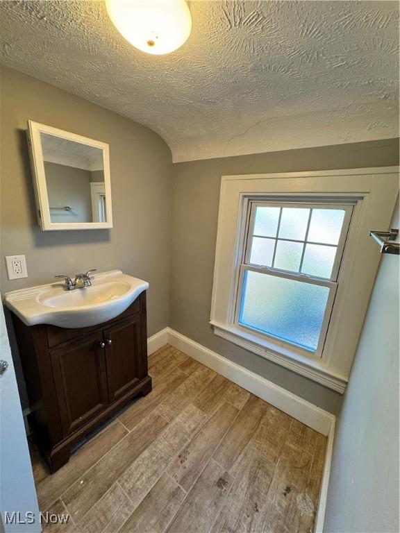 bathroom featuring vanity, wood-type flooring, and a textured ceiling