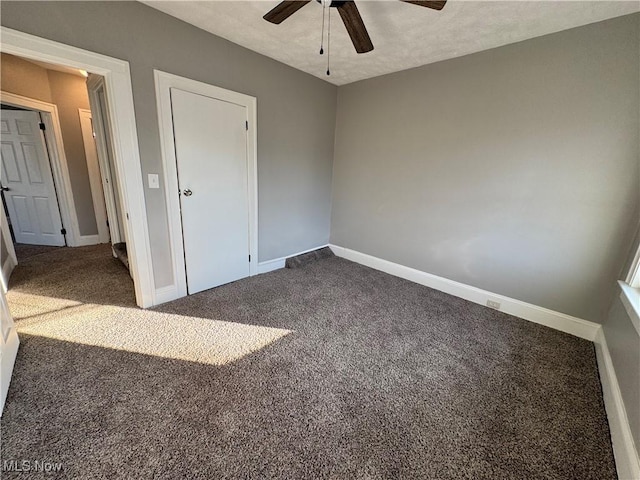 unfurnished bedroom with a textured ceiling, carpet floors, and ceiling fan