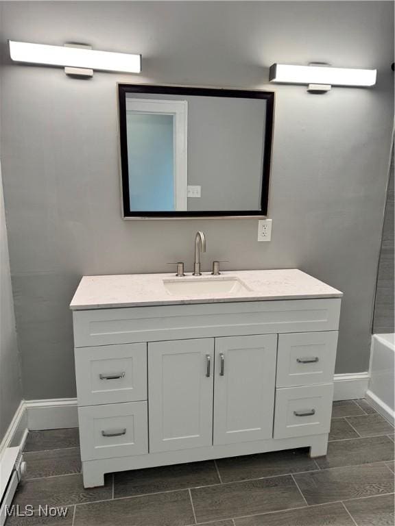 bathroom featuring vanity, wood-type flooring, and tub / shower combination