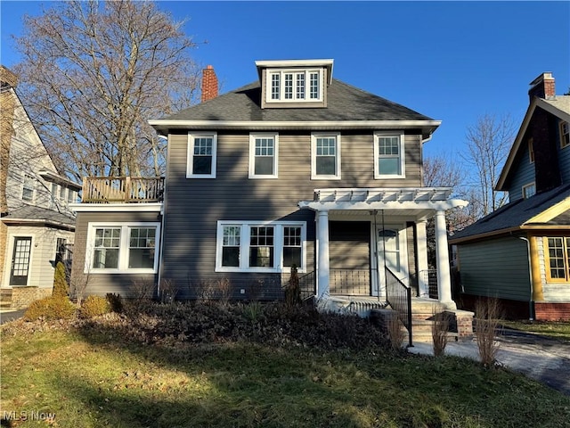 view of front of house with a pergola and a front lawn