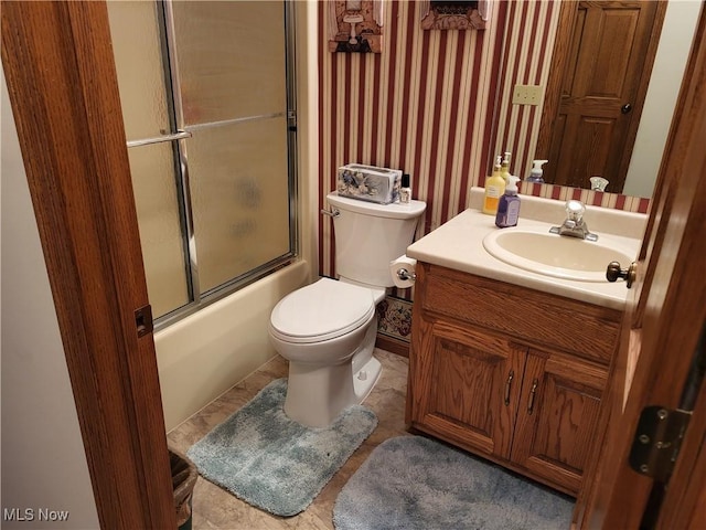 full bathroom featuring vanity, toilet, and combined bath / shower with glass door