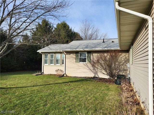 view of side of home with a lawn