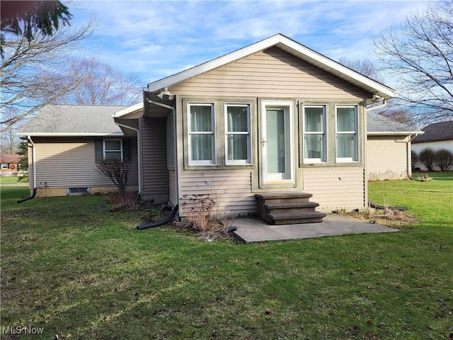 rear view of property featuring a lawn