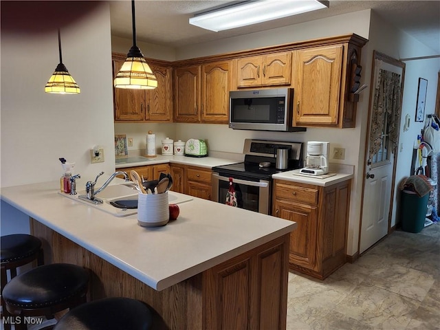 kitchen with kitchen peninsula, a kitchen breakfast bar, stainless steel appliances, sink, and hanging light fixtures