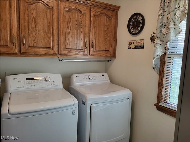 clothes washing area with cabinets and washer and dryer