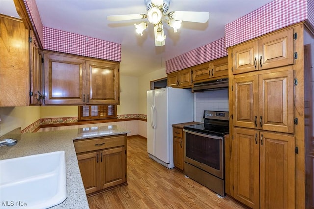 kitchen featuring sink, electric range, ceiling fan, white fridge with ice dispenser, and light hardwood / wood-style floors