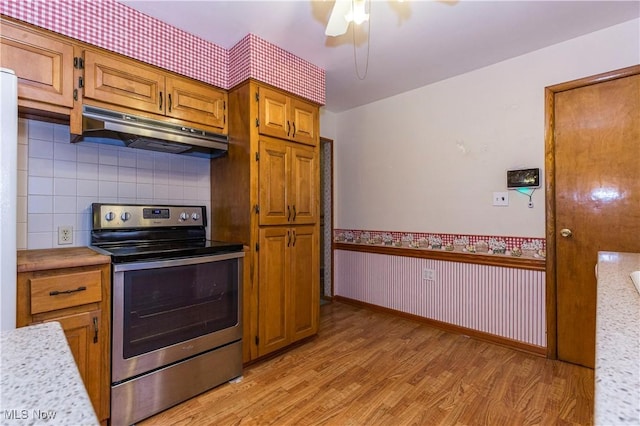 kitchen with tasteful backsplash, stainless steel electric range oven, light hardwood / wood-style flooring, and ceiling fan