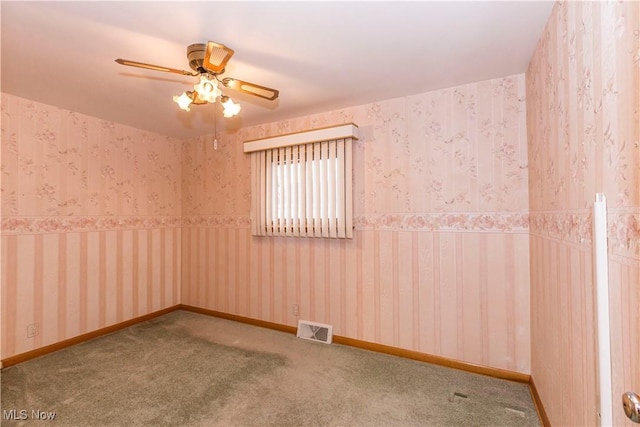 carpeted spare room featuring ceiling fan