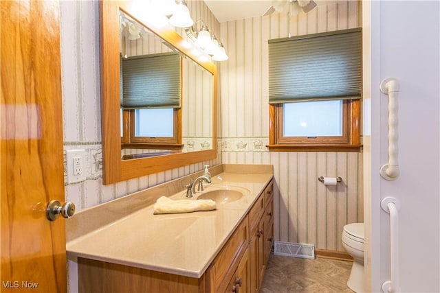 bathroom featuring vanity, toilet, and ceiling fan