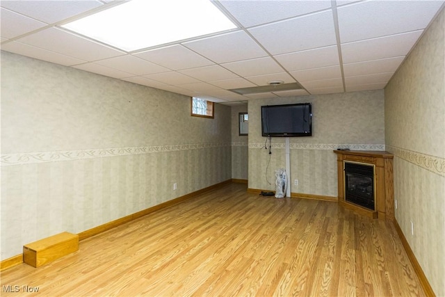 basement with hardwood / wood-style flooring and a drop ceiling