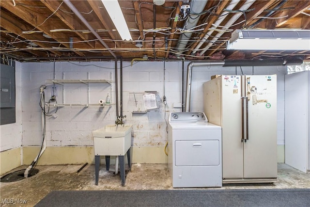 basement featuring washer / dryer, electric panel, white fridge, and sink