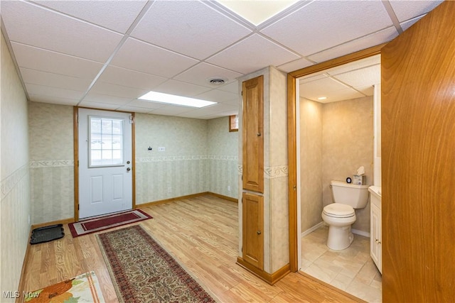 interior space with a paneled ceiling and light hardwood / wood-style flooring