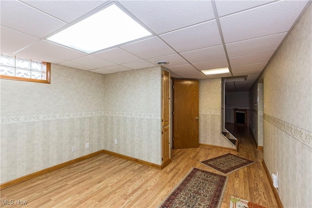 hall with light hardwood / wood-style floors and a drop ceiling