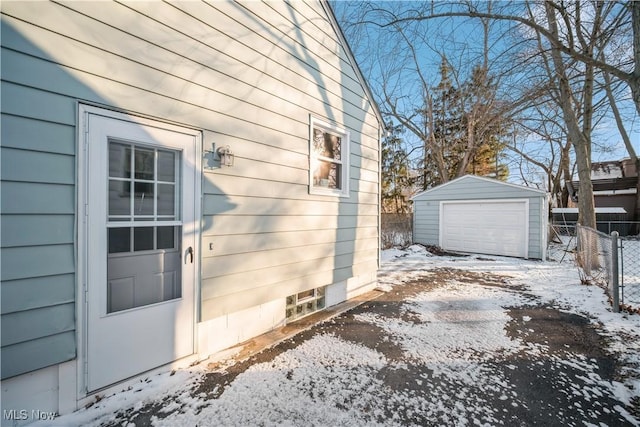 view of snowy exterior with a garage and an outdoor structure