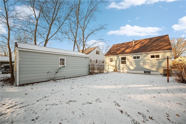 view of snow covered back of property