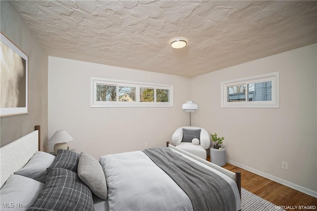 bedroom featuring wood-type flooring and a textured ceiling