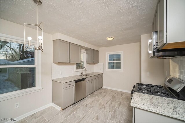 kitchen with gray cabinetry, sink, tasteful backsplash, pendant lighting, and appliances with stainless steel finishes