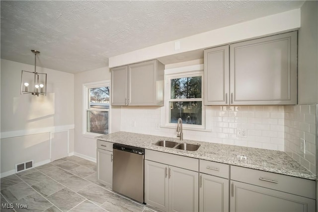 kitchen featuring an inviting chandelier, sink, hanging light fixtures, stainless steel dishwasher, and tasteful backsplash