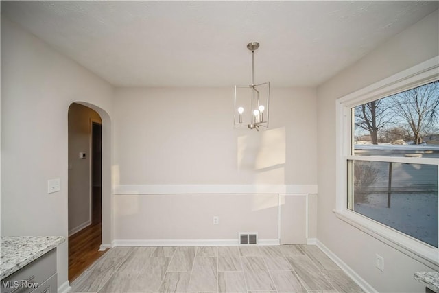 unfurnished dining area featuring a chandelier and light hardwood / wood-style floors