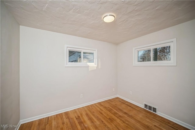 unfurnished room featuring hardwood / wood-style floors and a textured ceiling