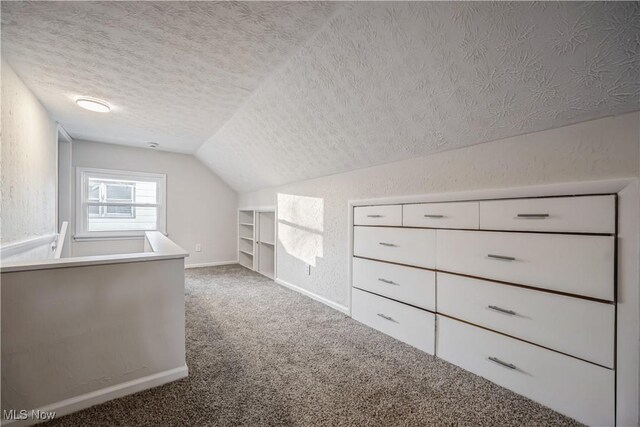 bonus room with a textured ceiling, carpet floors, and vaulted ceiling