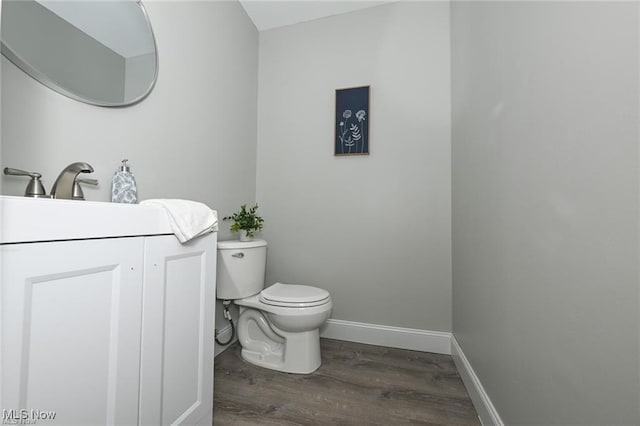 bathroom with vanity, hardwood / wood-style flooring, and toilet