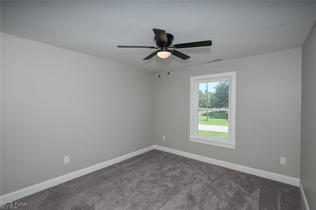 unfurnished room with ceiling fan and dark carpet