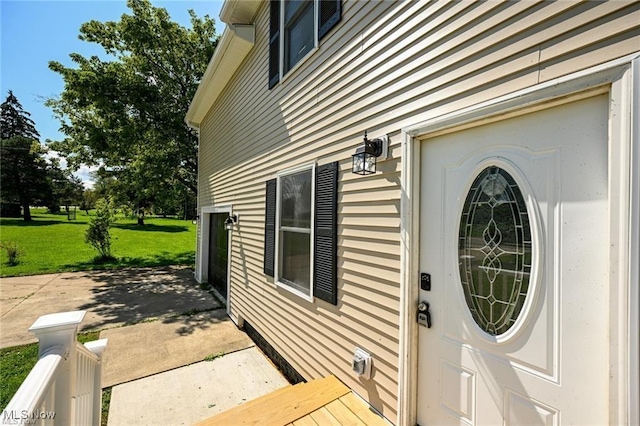 entrance to property featuring a lawn