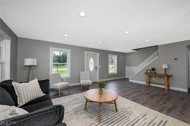 living room with plenty of natural light and dark wood-type flooring