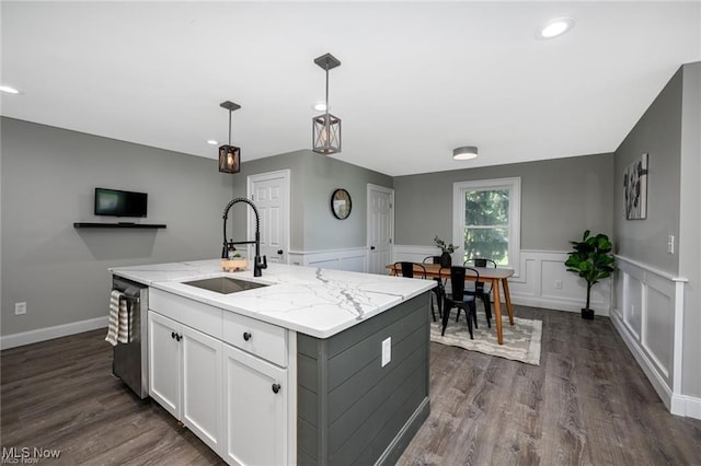 kitchen featuring dishwasher, sink, hanging light fixtures, a center island with sink, and white cabinets