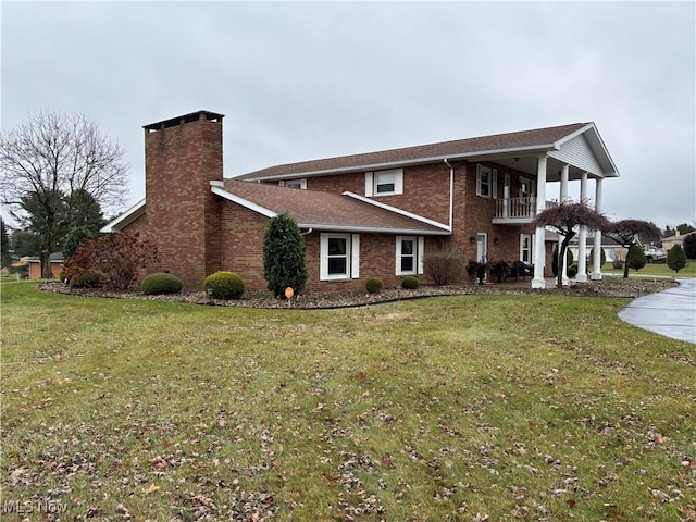 view of front facade featuring a balcony and a front lawn