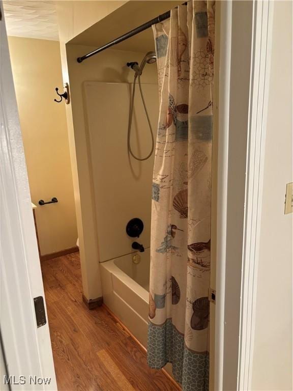 bathroom featuring shower / bathtub combination with curtain and wood-type flooring