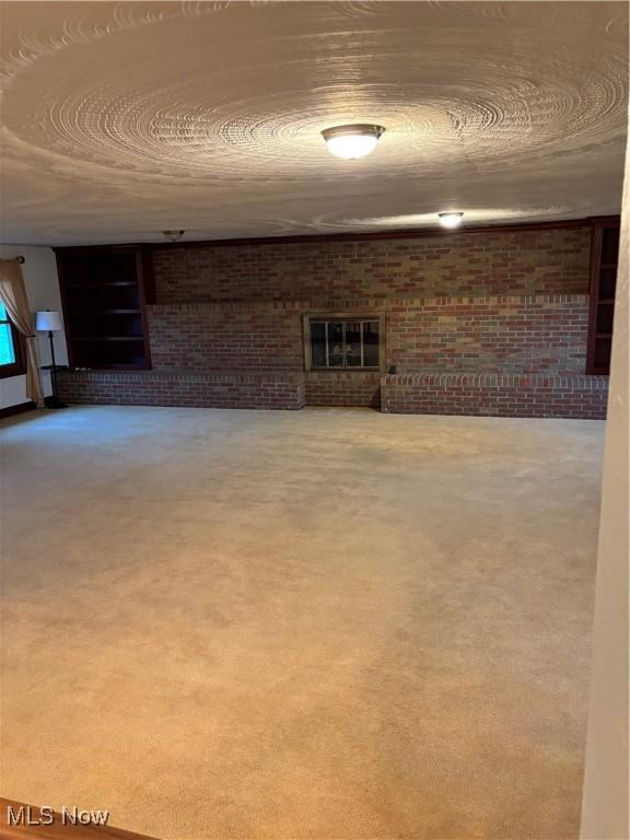 basement with a fireplace and brick wall