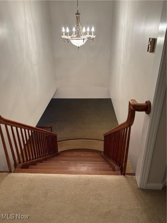 stairs featuring carpet floors and a notable chandelier