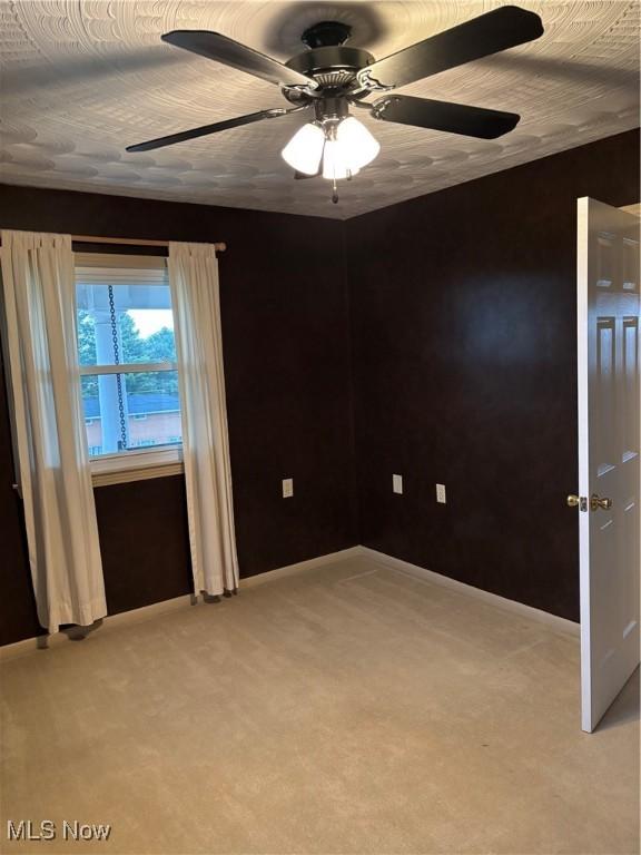 carpeted empty room with ceiling fan