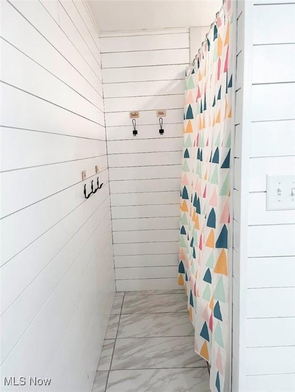 mudroom featuring wood walls