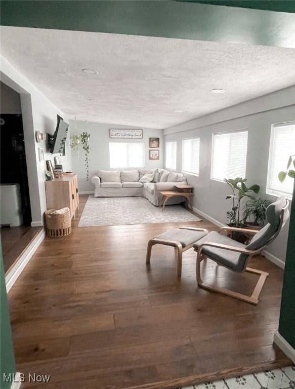 interior space with plenty of natural light, dark wood-type flooring, and a textured ceiling