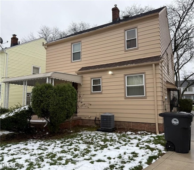 snow covered back of property with central AC unit