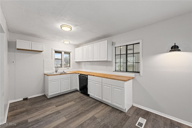 kitchen featuring white cabinets, butcher block countertops, dishwasher, and sink