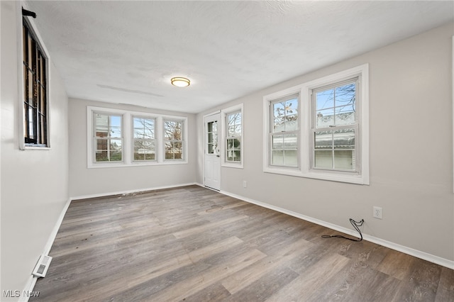 spare room with hardwood / wood-style flooring and a textured ceiling