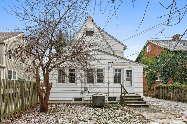 snow covered back of property with central AC