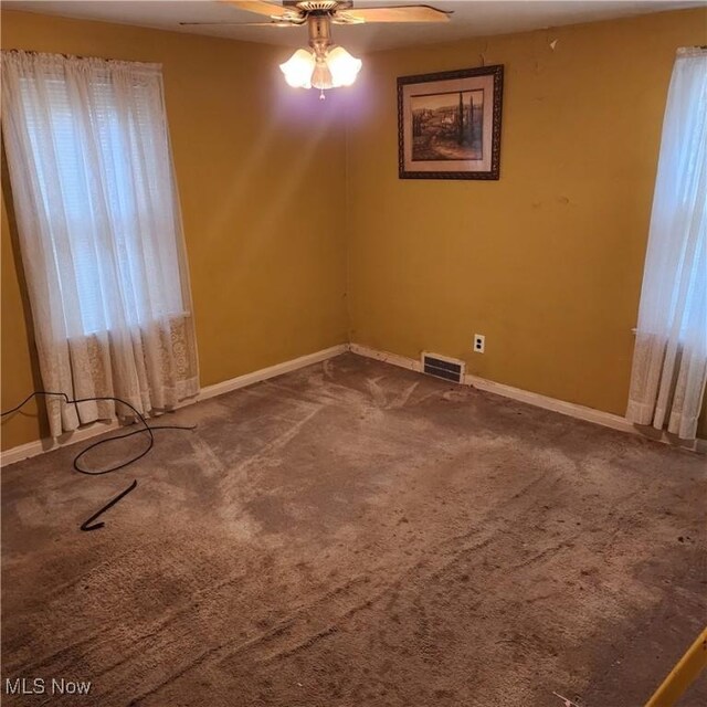 carpeted empty room with ceiling fan and a healthy amount of sunlight