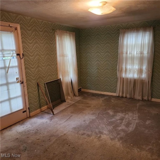 carpeted spare room featuring a textured ceiling