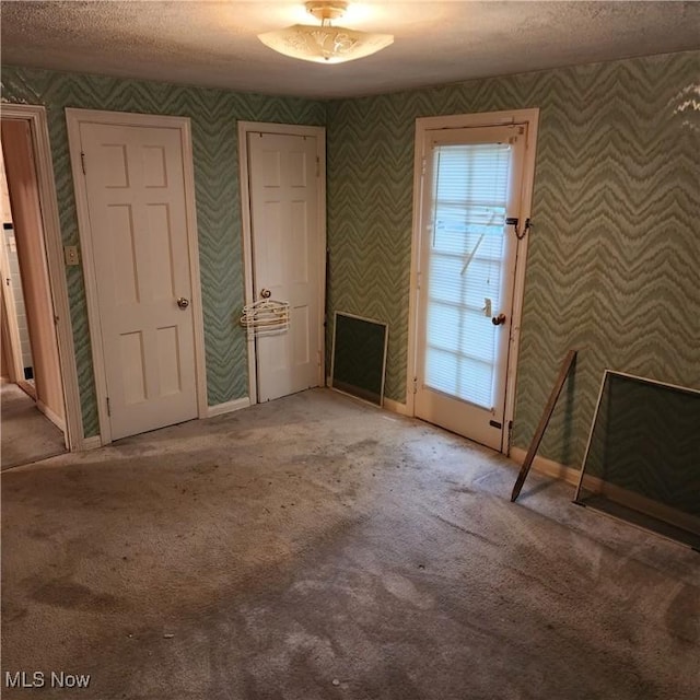 unfurnished living room with a textured ceiling and light carpet