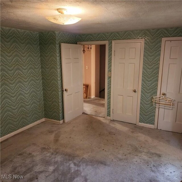 unfurnished room featuring carpet flooring and a textured ceiling