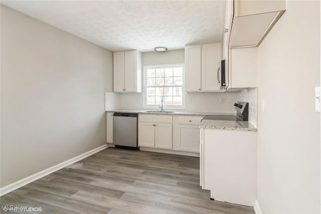 kitchen with white cabinets, sink, light wood-type flooring, a textured ceiling, and appliances with stainless steel finishes