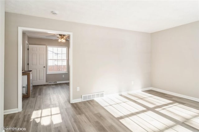 empty room with light hardwood / wood-style flooring and ceiling fan