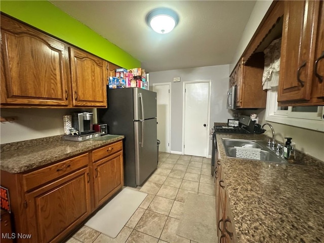 kitchen featuring light tile patterned floors, stainless steel appliances, and sink